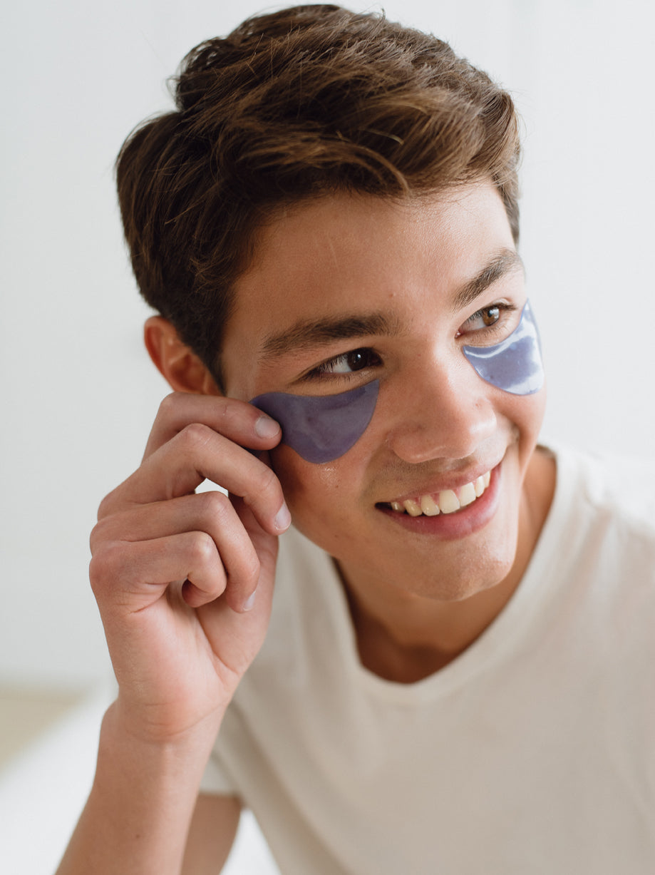 Person smiling and wearing Swimming Under The Eyes Brightening Gel Pads